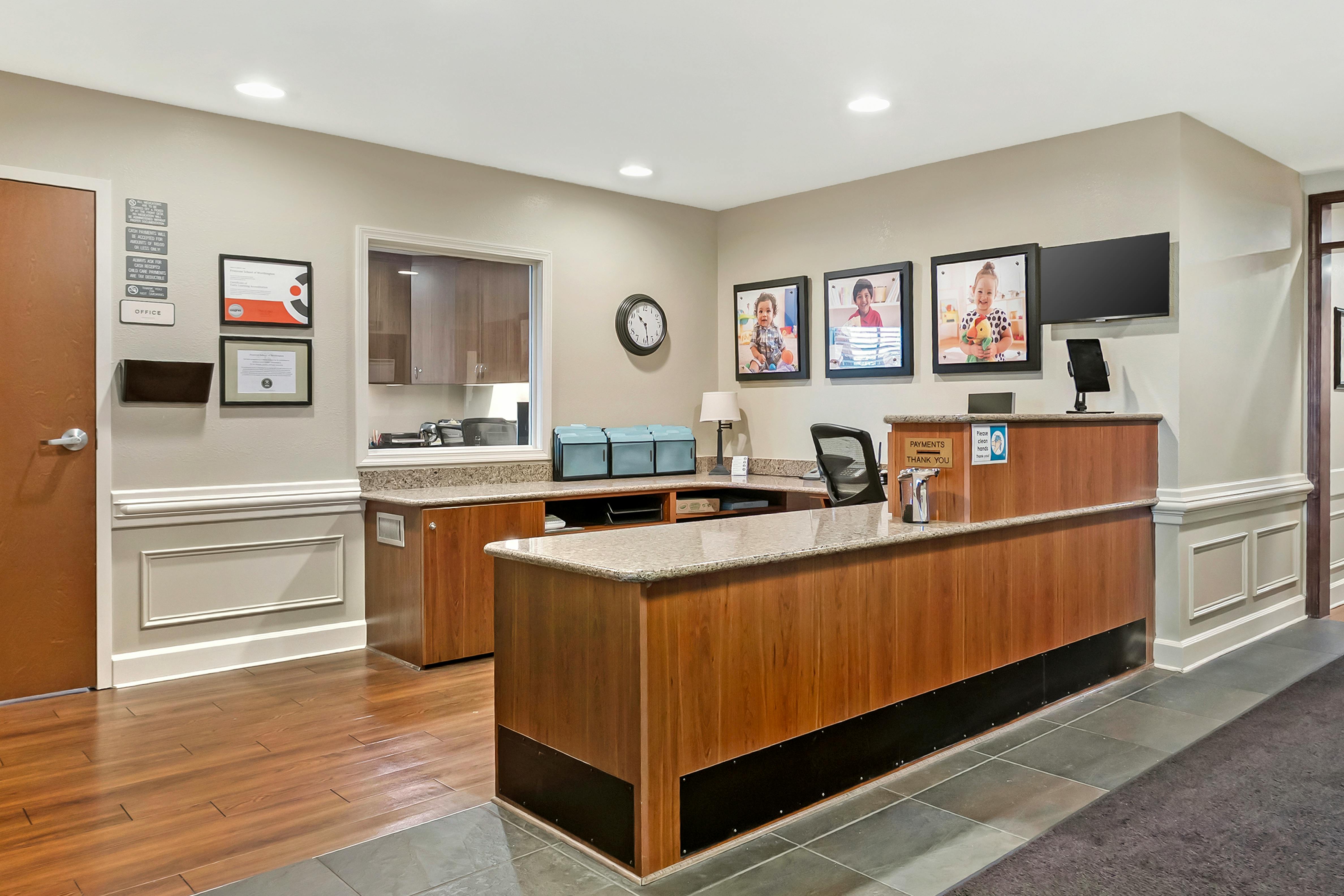 Reception desk with office door, window, pictures of children, and a payment sign