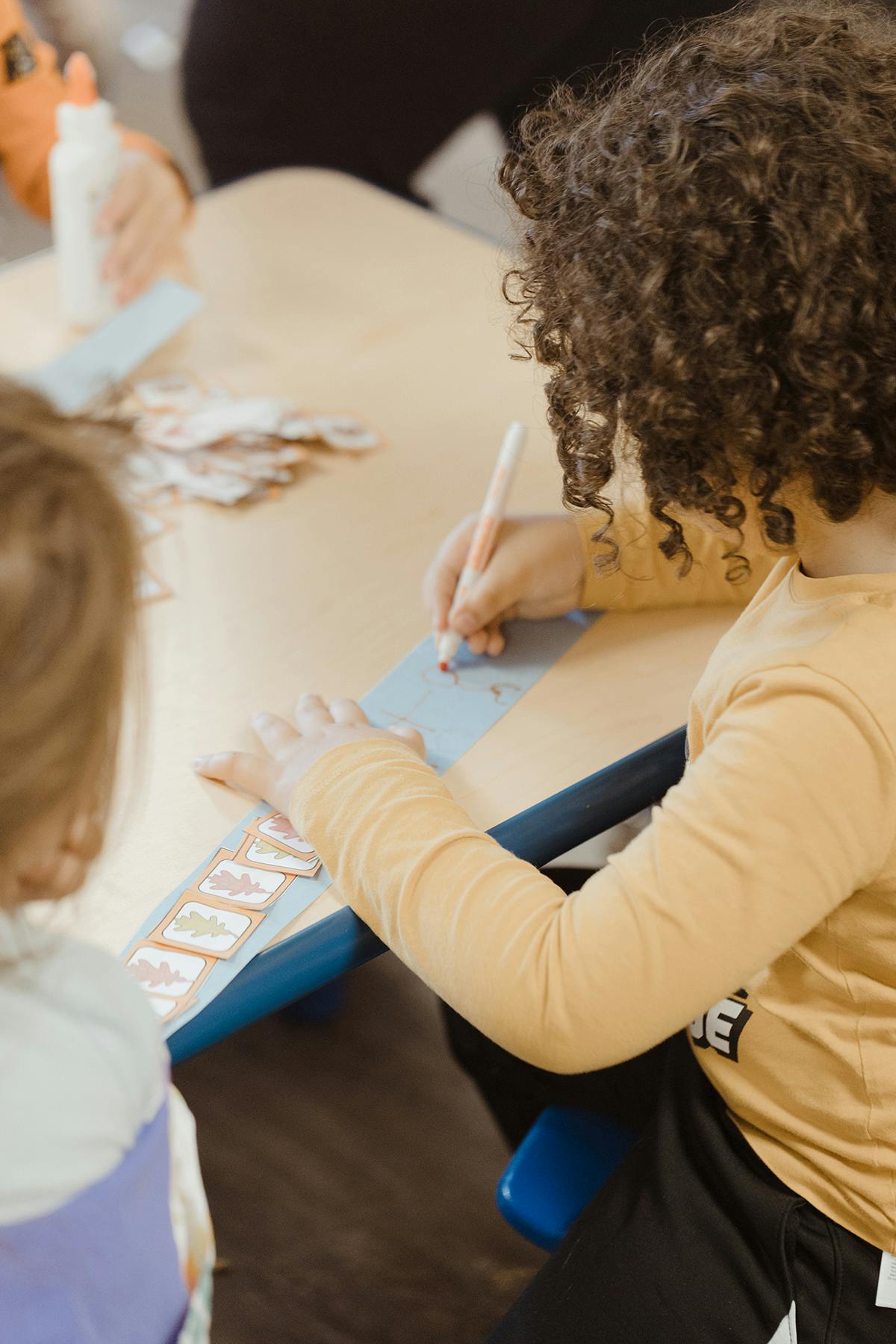 Child writing on paper at a table
