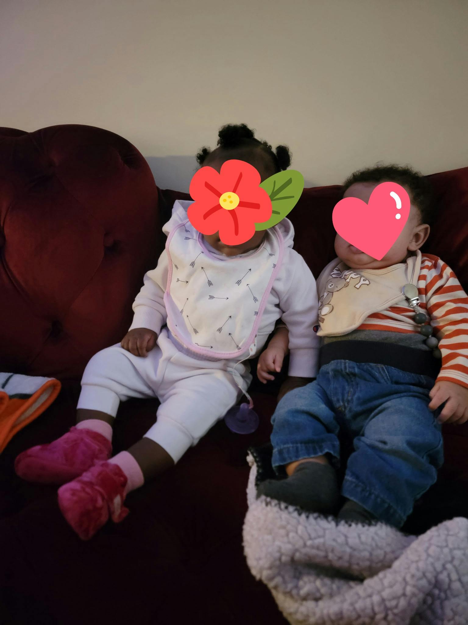 two children wearing bibs sitting on a couch