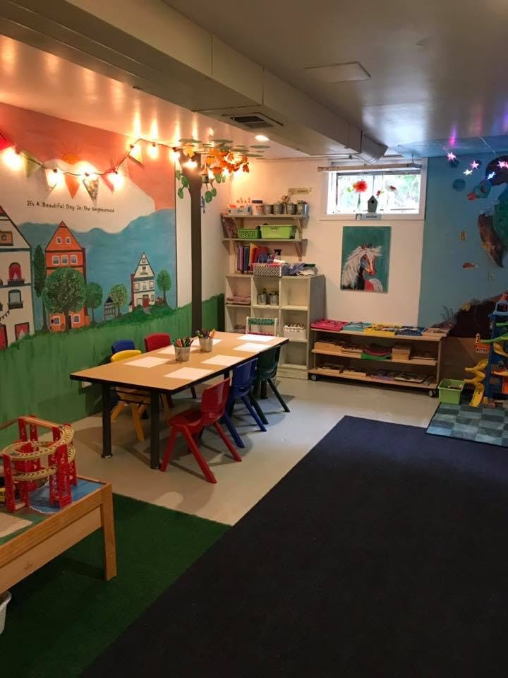 Children's classroom with a long table and colorful chairs