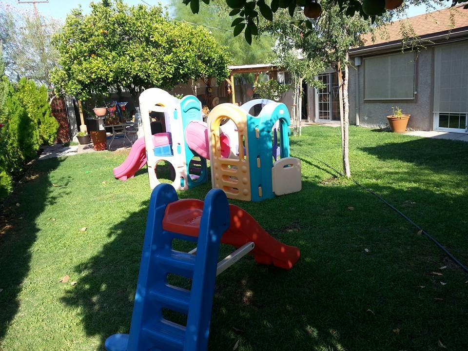 Playground with colorful slides and play structures on a grassy lawn