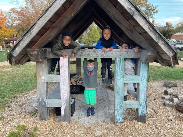 Children playing in a wooden playhouse