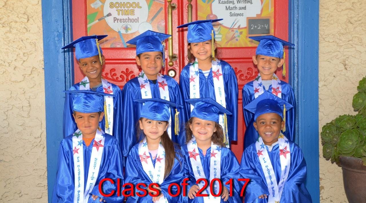 Group of children in blue graduation caps and gowns