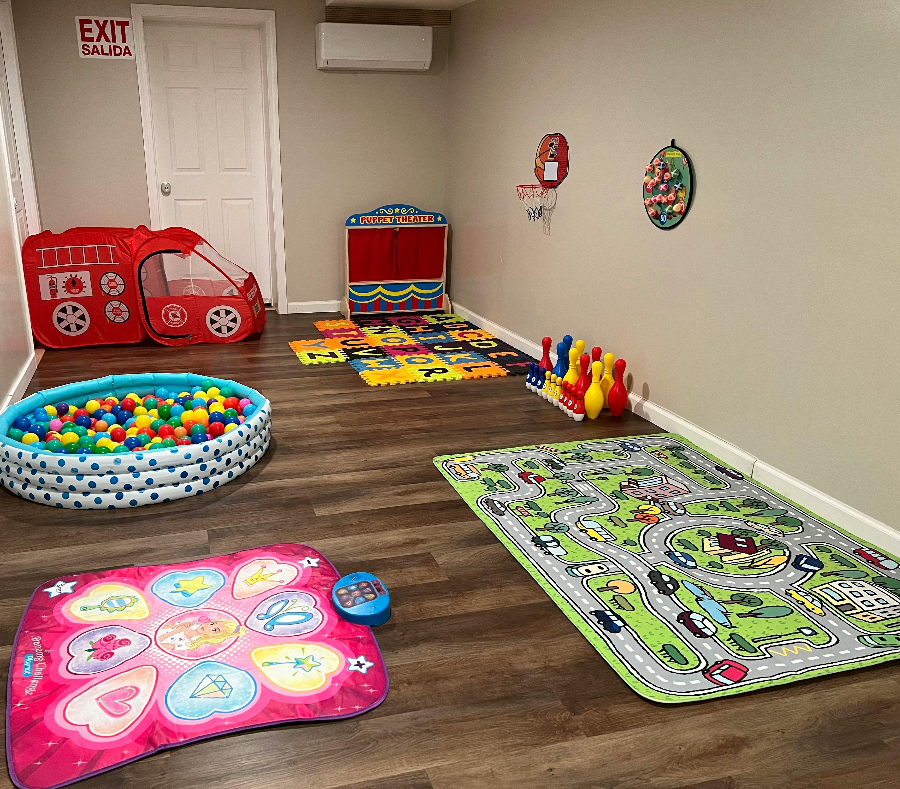 Playroom with a ball pit, play mat, and toy fire truck