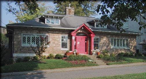 Stone house with a red front door and red awning