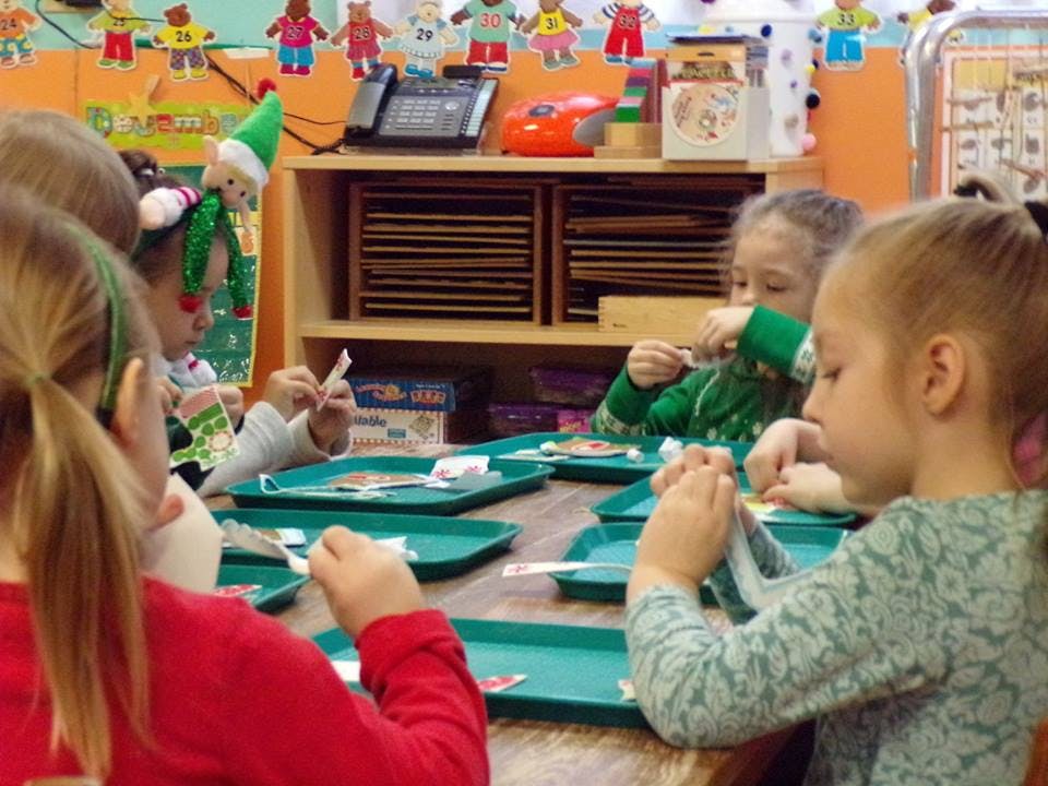 Children at a table doing an activity with small trays