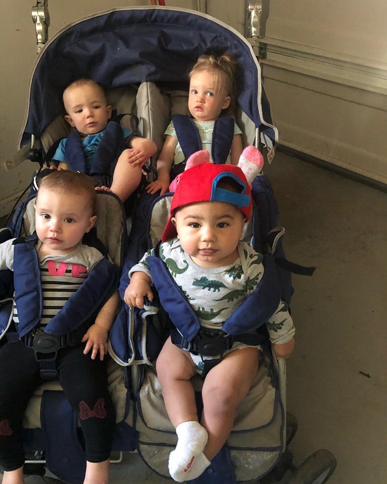 Four children in a multi-seat stroller