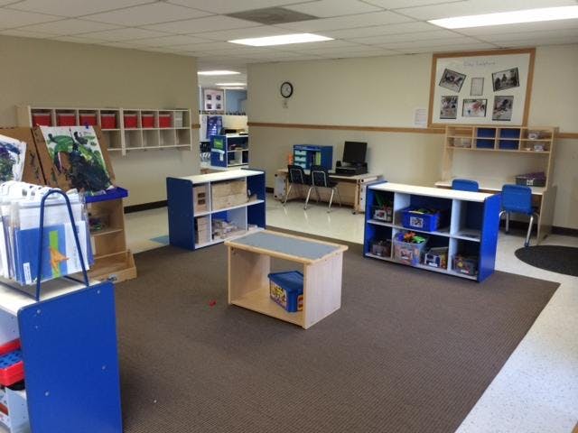 Classroom with shelves, art easels, and small furniture