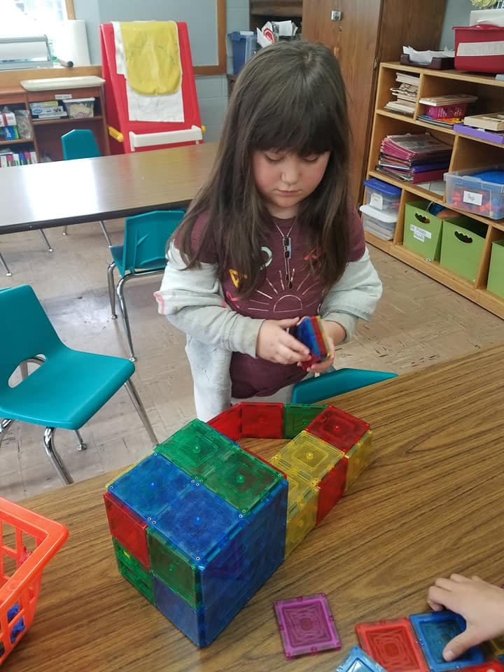 Child playing with colorful magnetic blocks on a table