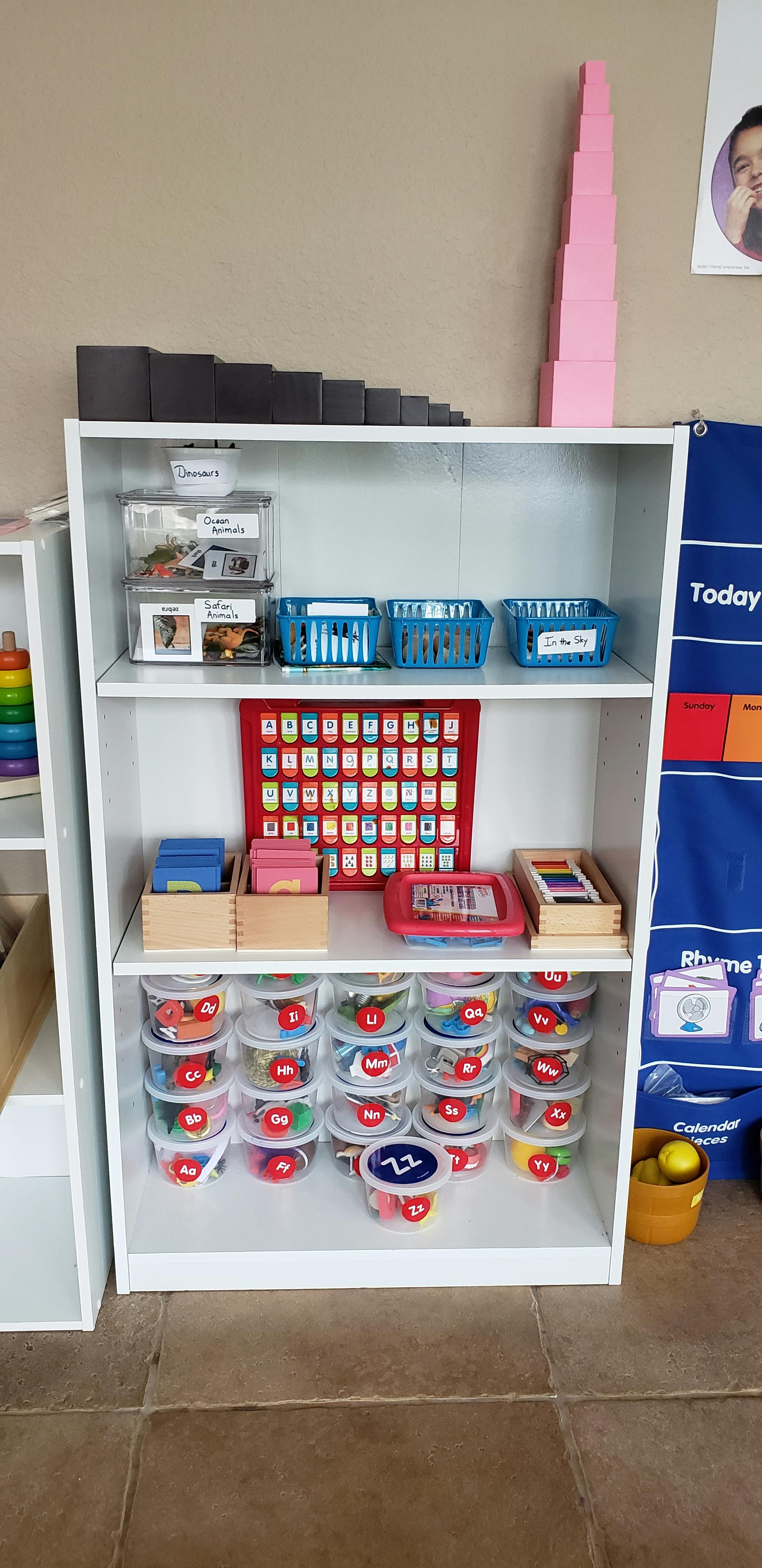 White shelving unit with various educational materials and containers