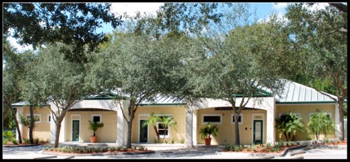 Building with multiple entrances and trees in front