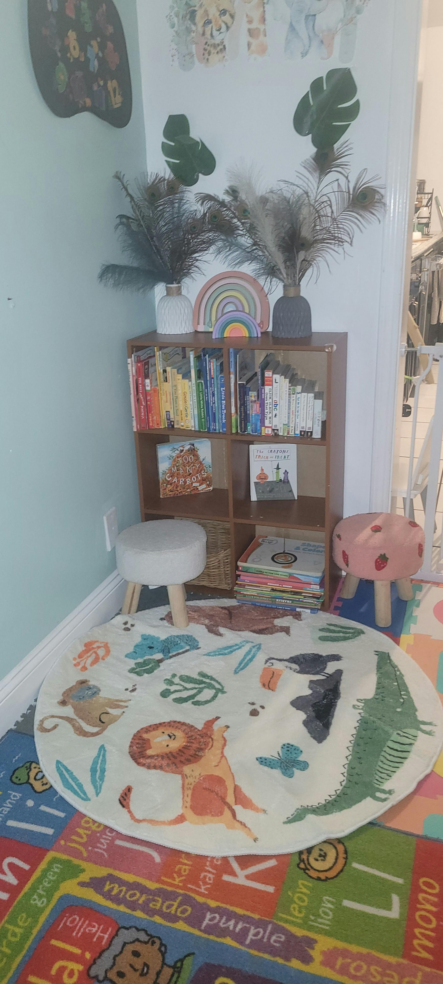 Children's reading nook with a bookshelf, stools, and animal-themed rug