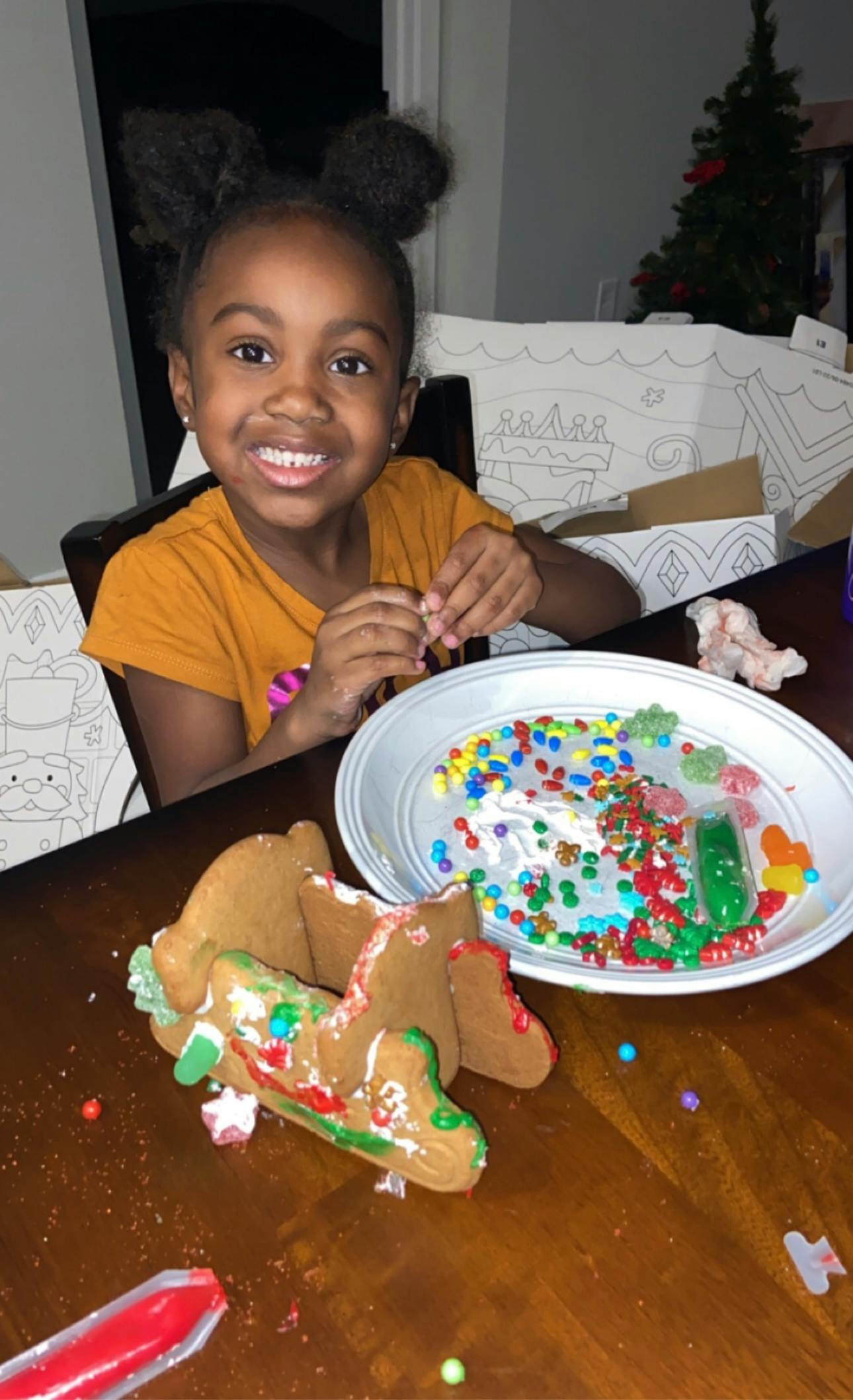 Child decorating gingerbread cookies at a table