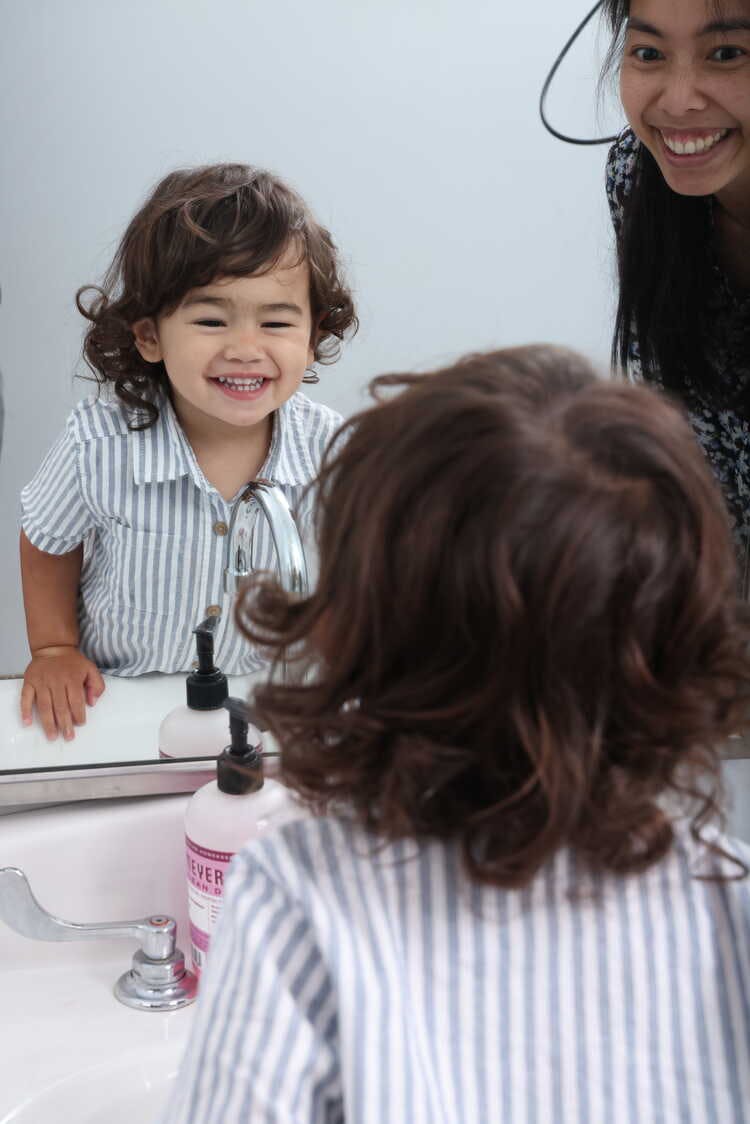 Child looking in a mirror in a bathroom