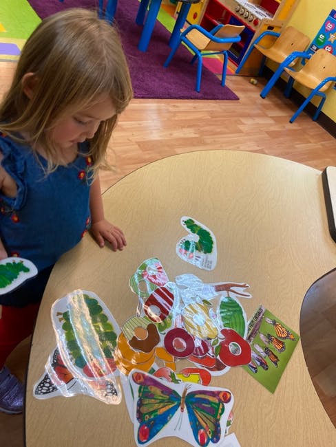 Child looking at colorful cutouts on a table