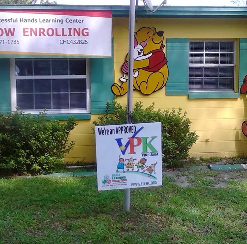 Building with a "Now Enrolling" banner and a VPK program sign