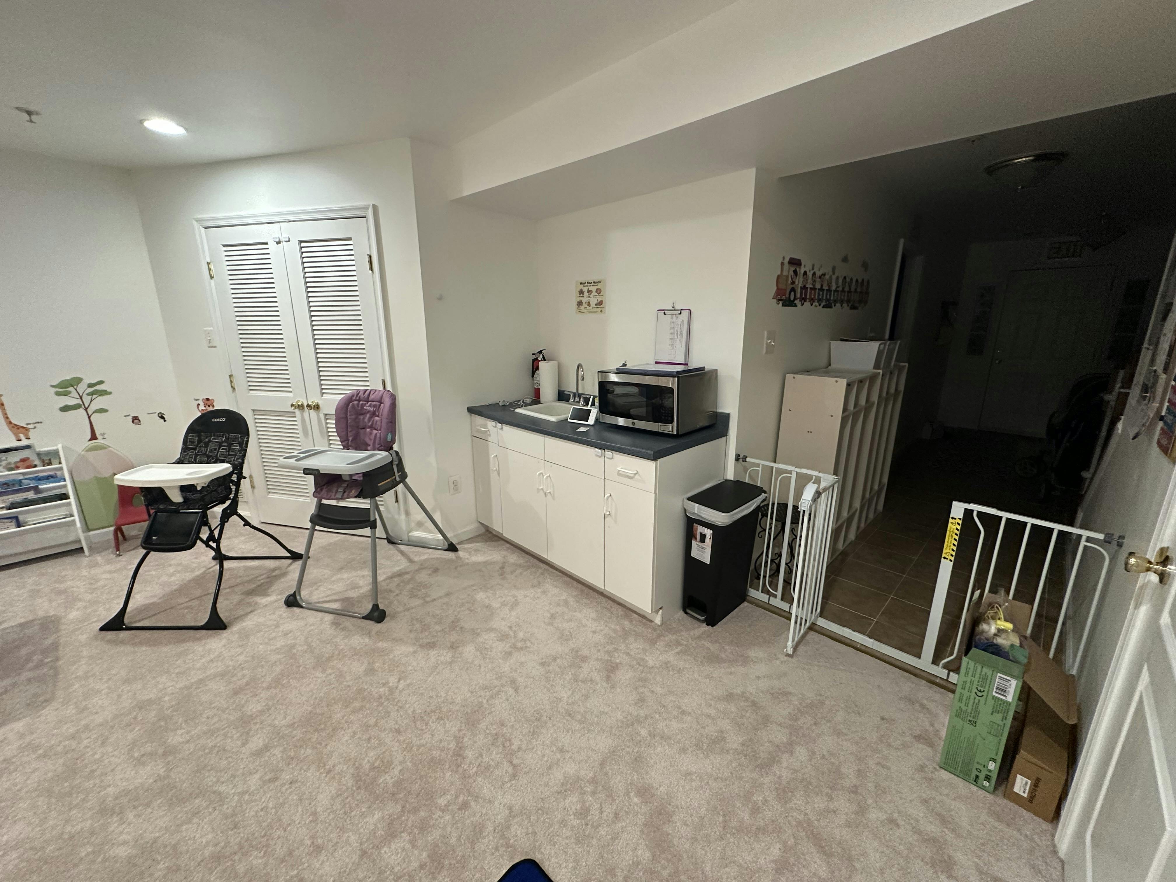 Two high chairs in a room with a counter and microwave