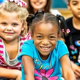 Child with pigtails smiling at the camera