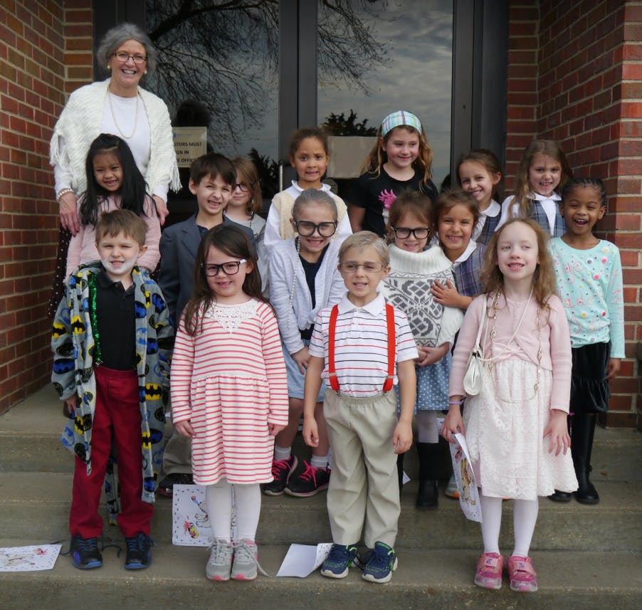 Adult and group of children standing on steps