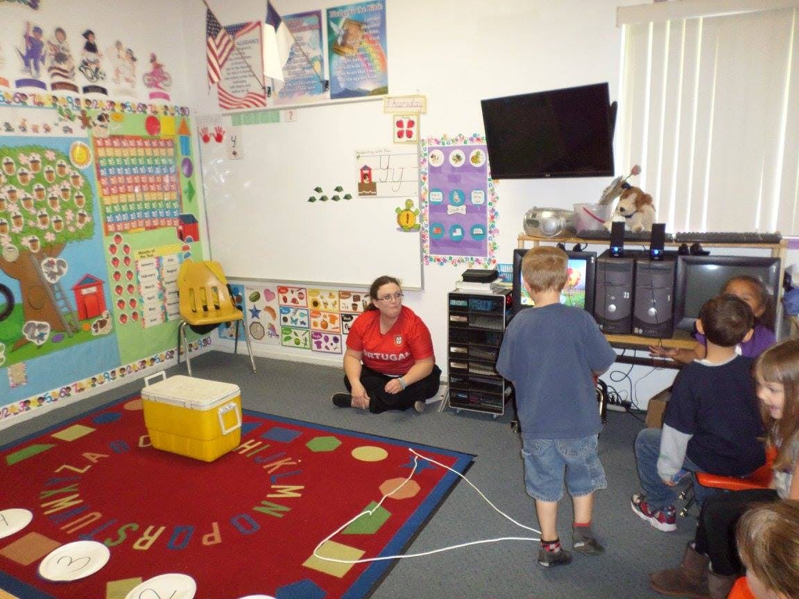 Adult and children in a classroom with computers