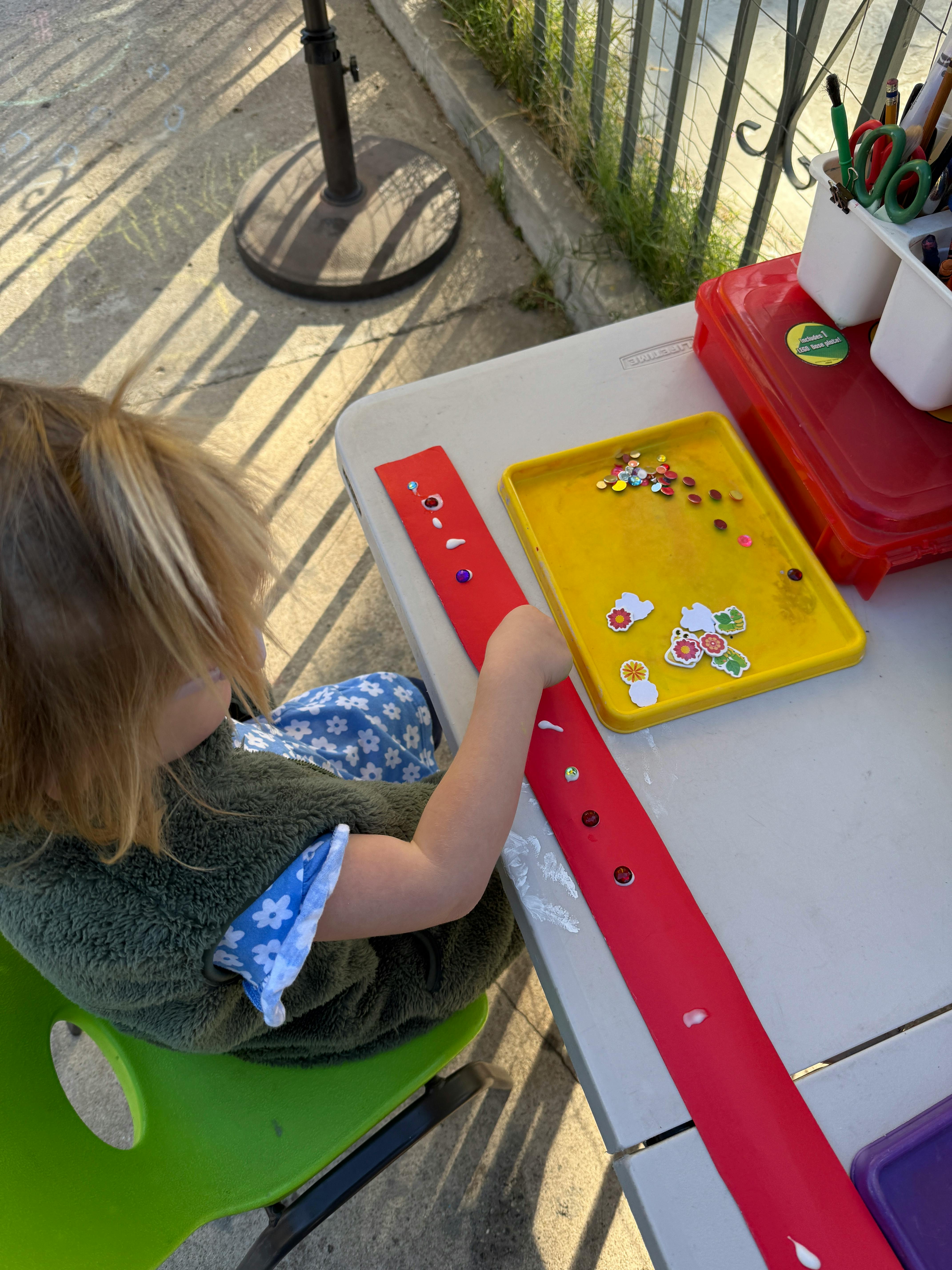 Child sitting at a table with craft supplies