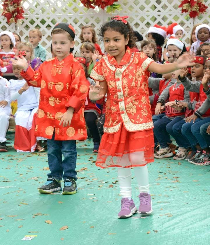 Two children in red traditional clothing performing
