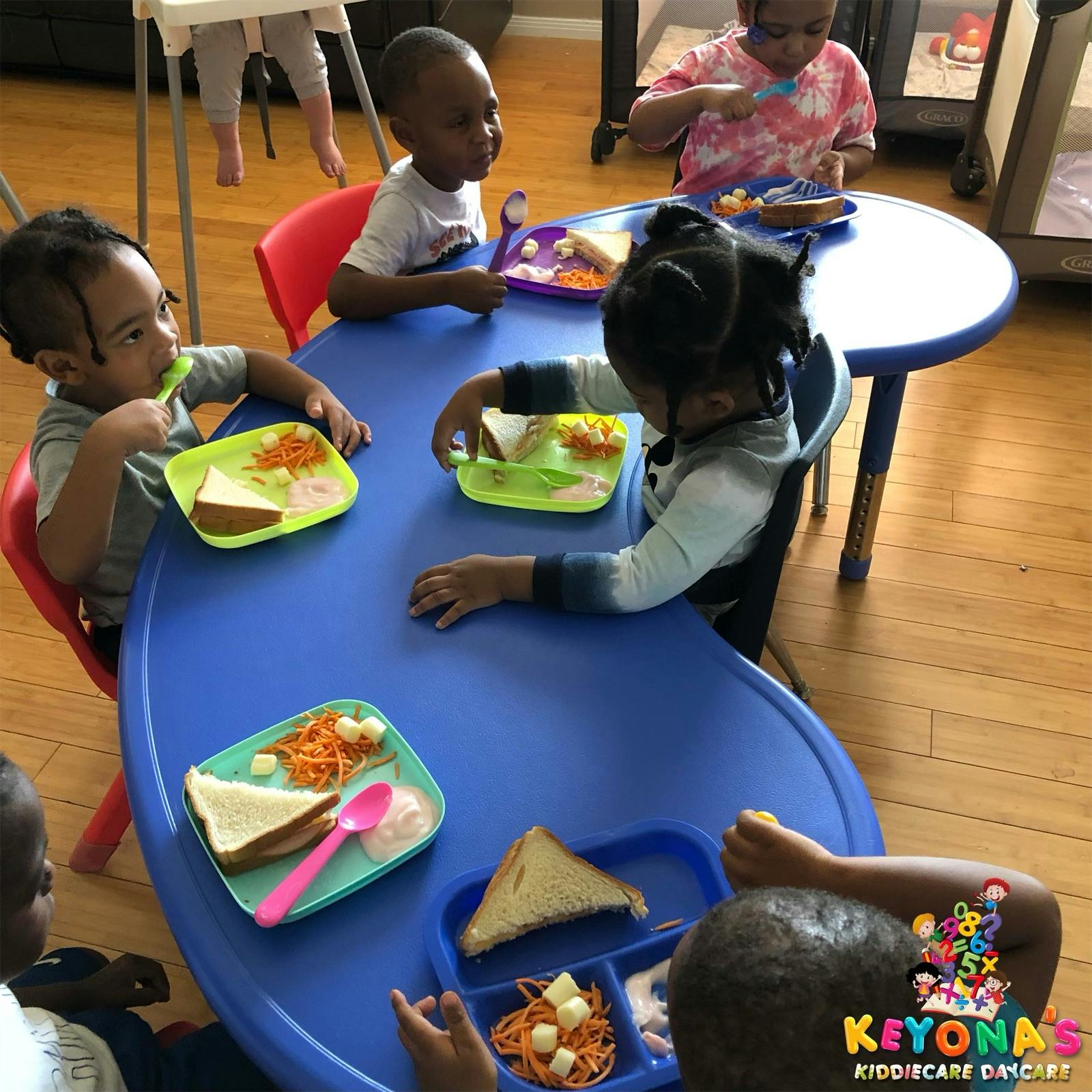 Children eating meals at a blue table