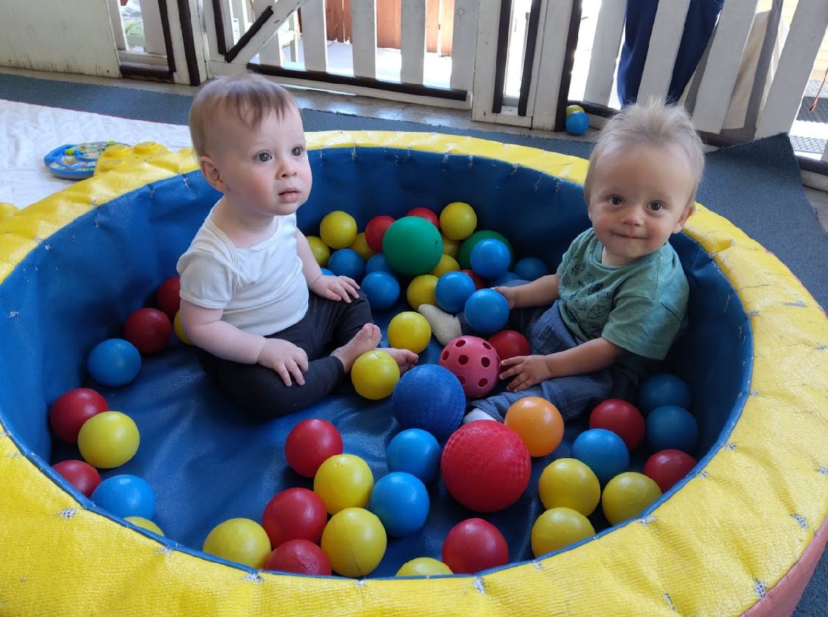 Two children sitting in a ball pit
