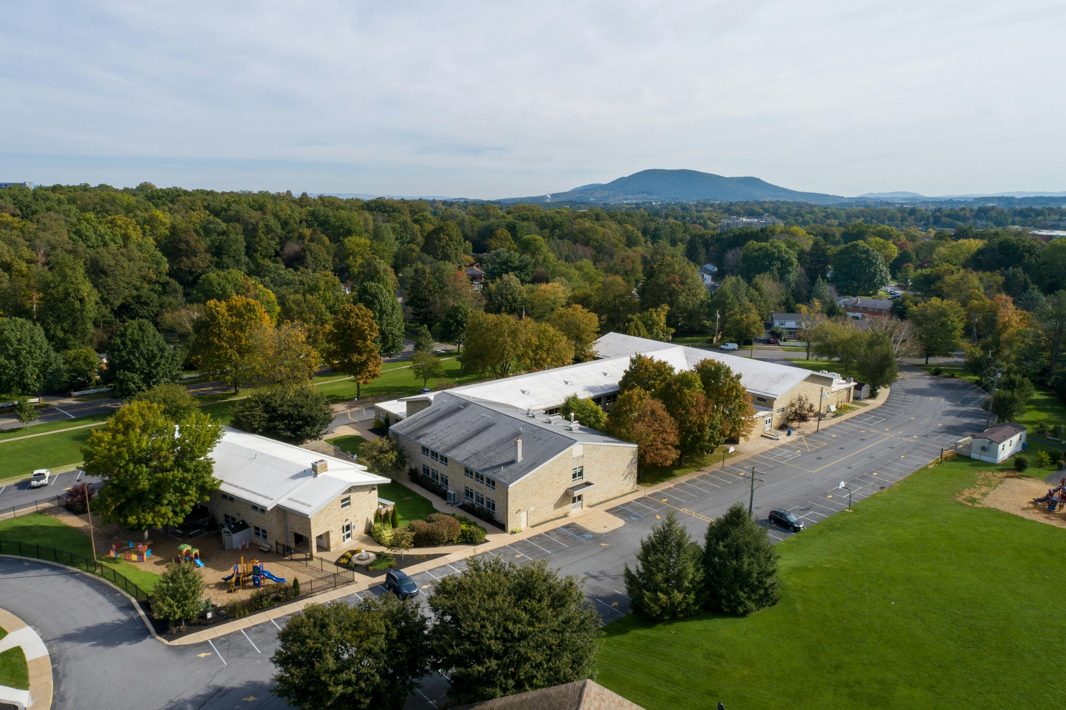 Aerial view of a school campus with multiple buildings, playgrounds, and parking lots