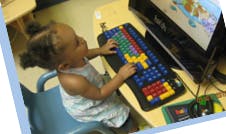 Child using a computer with a colorful keyboard