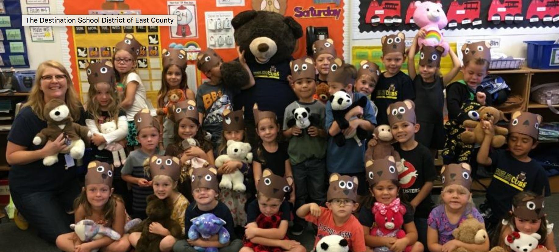 Adult and children wearing bear headbands, holding stuffed animals