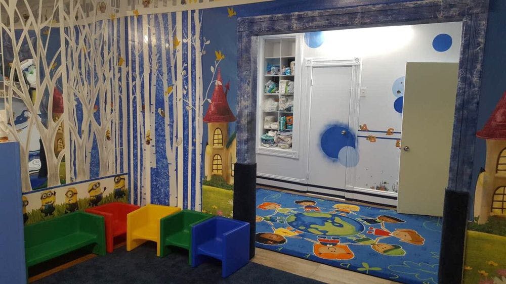 Children's play area with colorful chairs and a mural of a forest mural of a forest