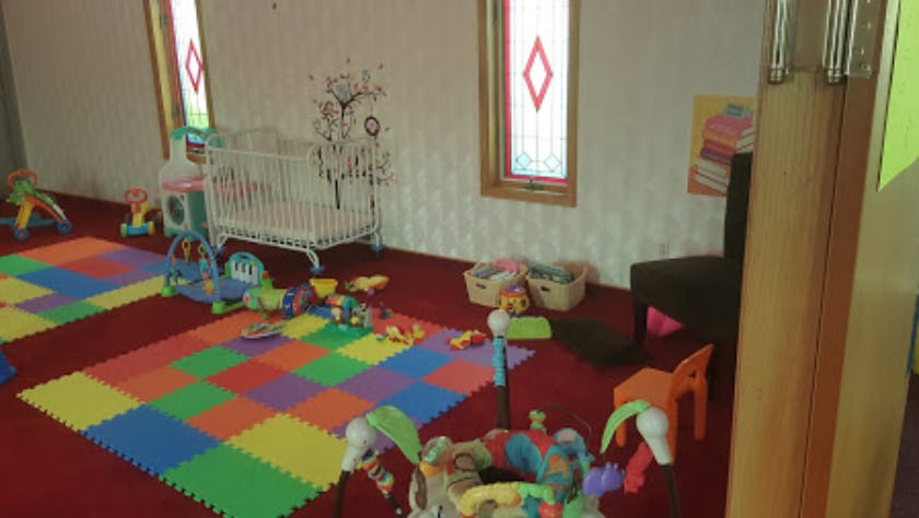 Playroom with colorful floor mats, crib, and various toys