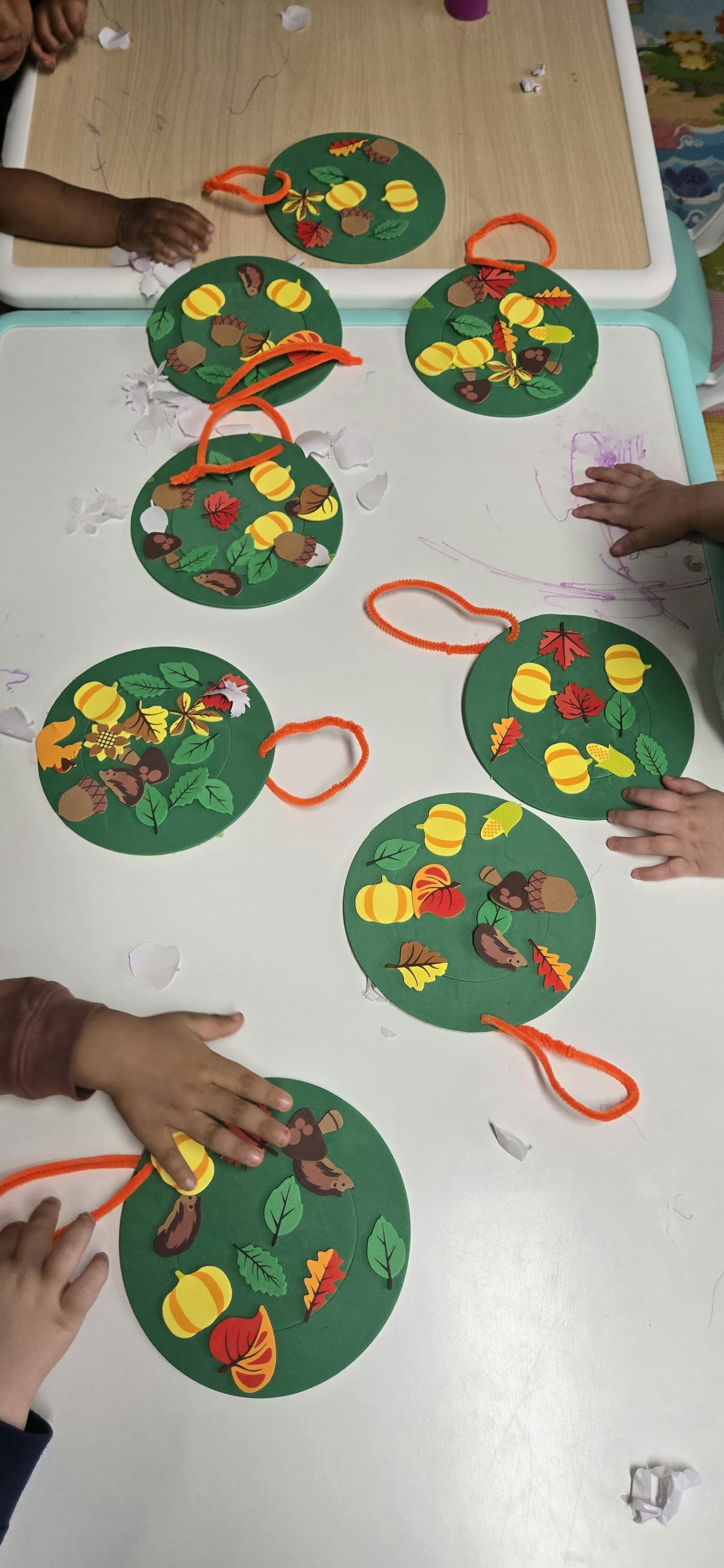 Children working on autumn themed foam circle crafts at a table