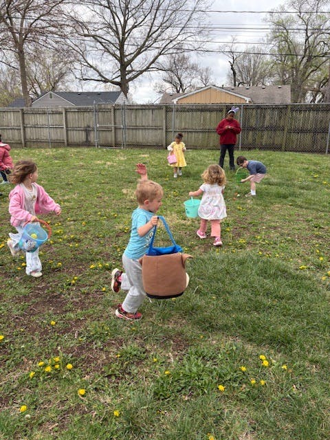 Children walking on grass carrying baskets during an easter egg hunt