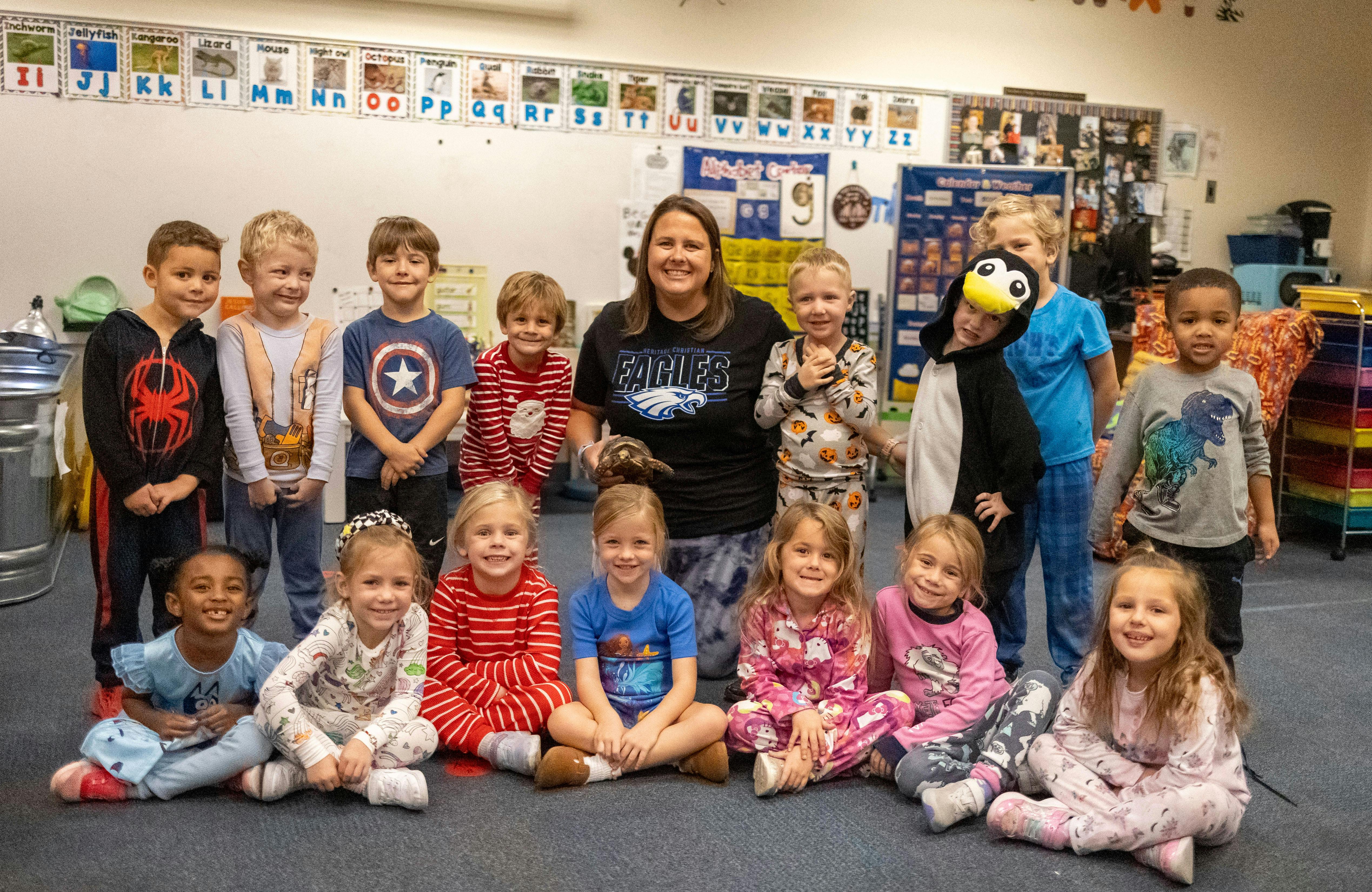 Adult and children posing in a classroom