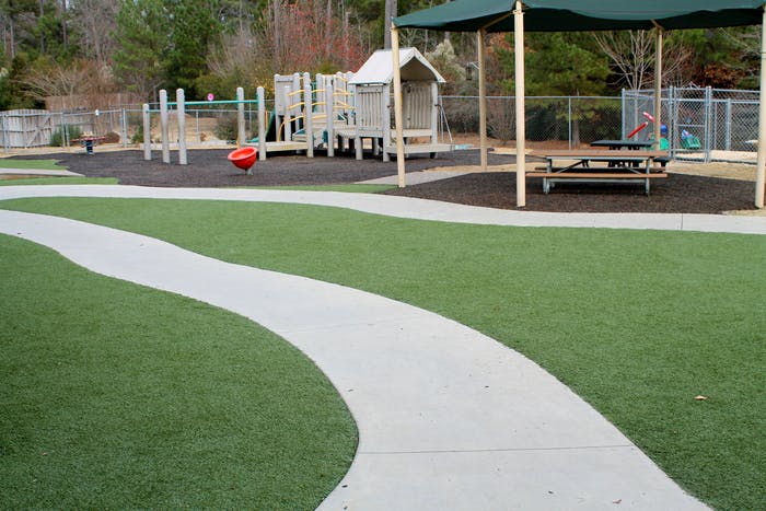 Playground with a winding path, play structure, and covered picnic table