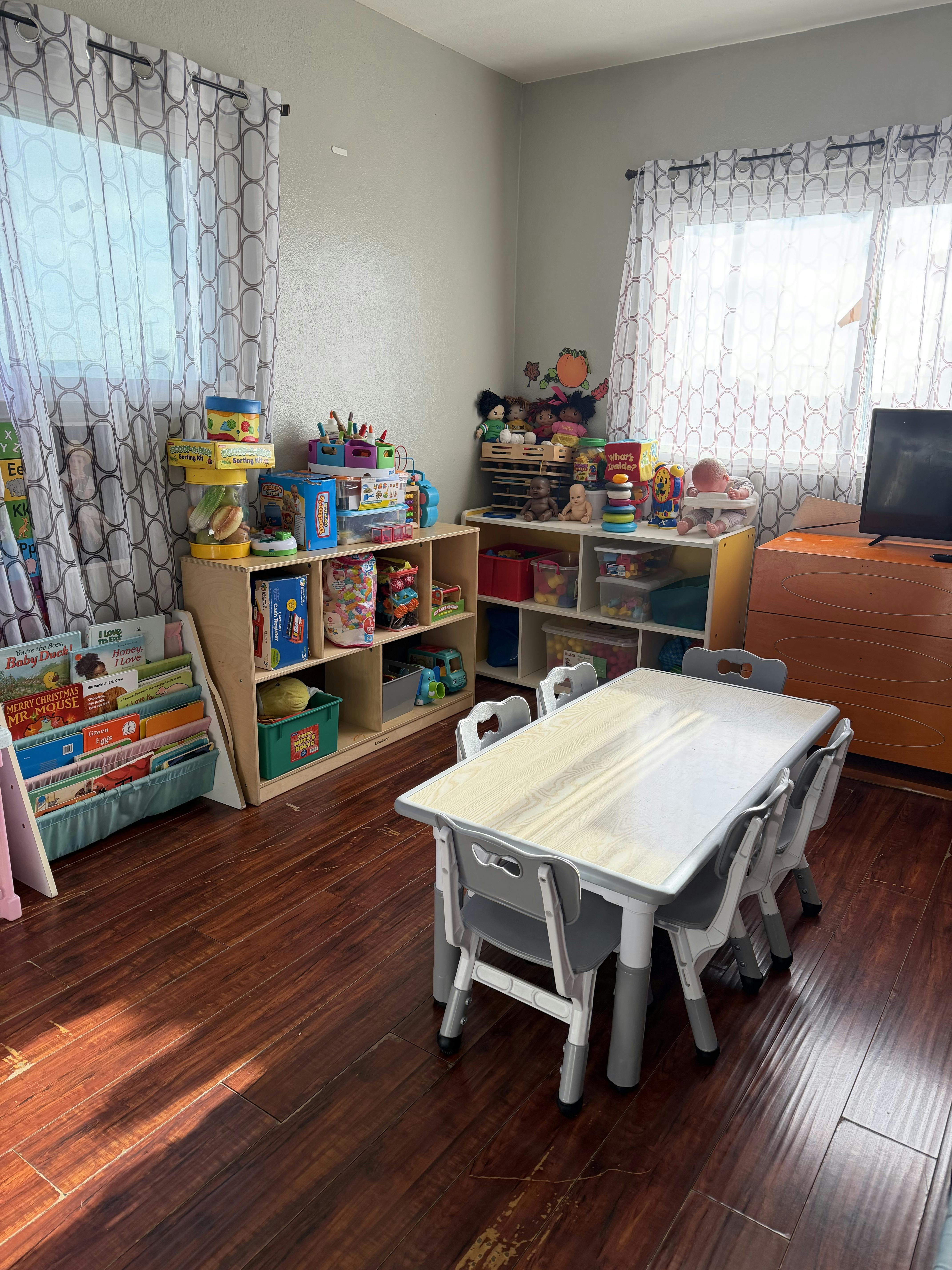 children's play area with a small table and chairs, toys, and books