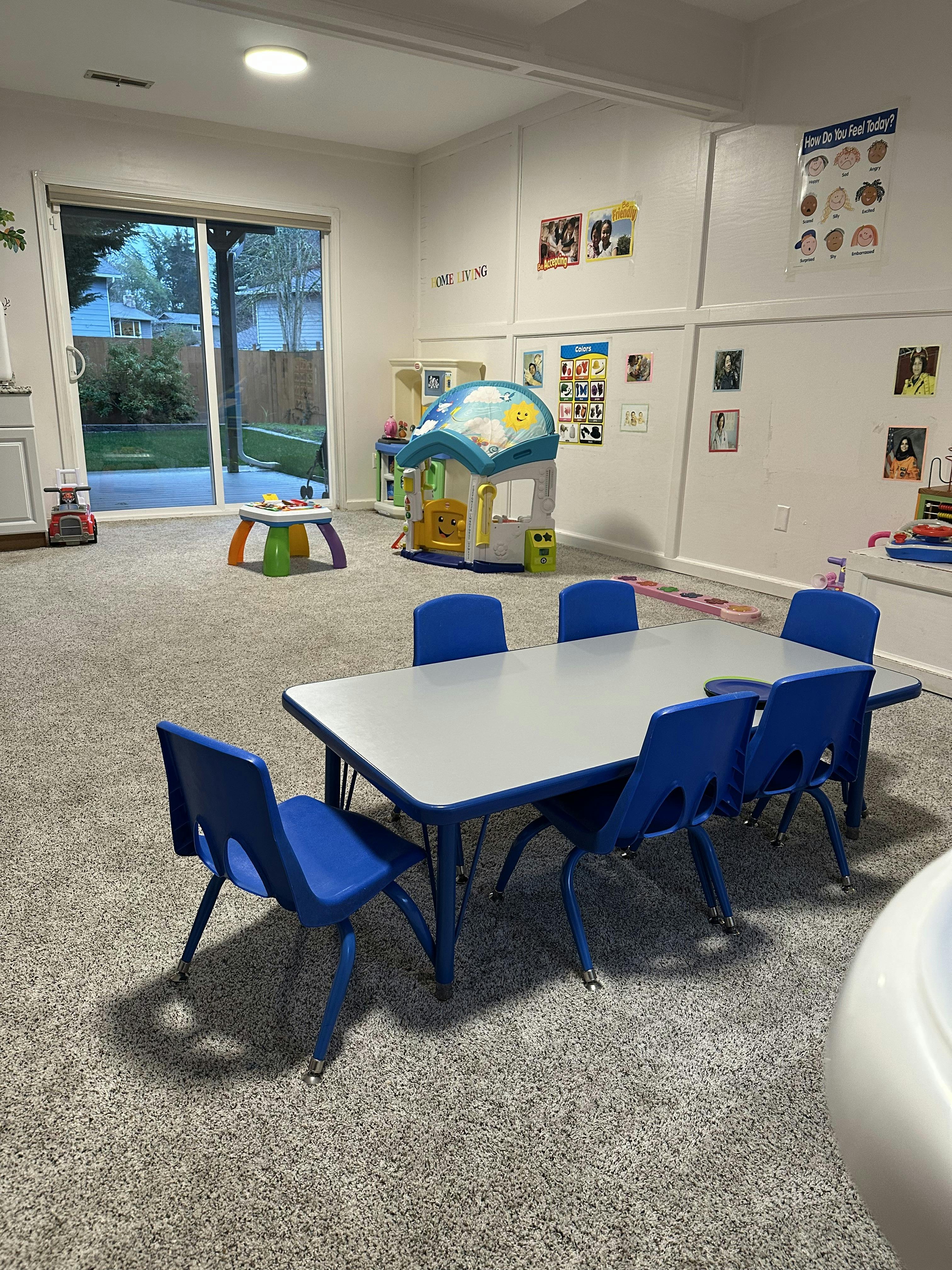 Playroom with small table and chairs, toys, and sliding glass door