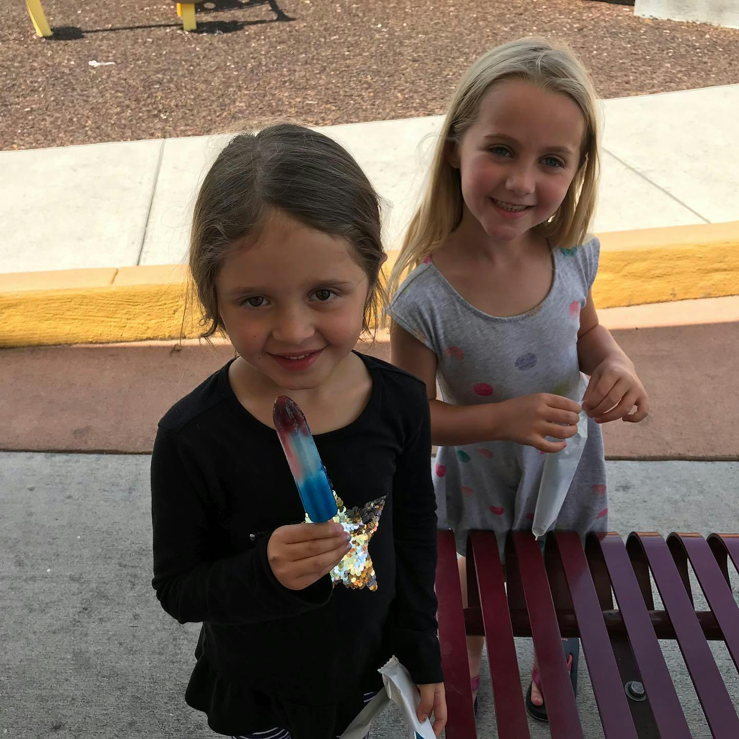 Two children, one holding a popsicle