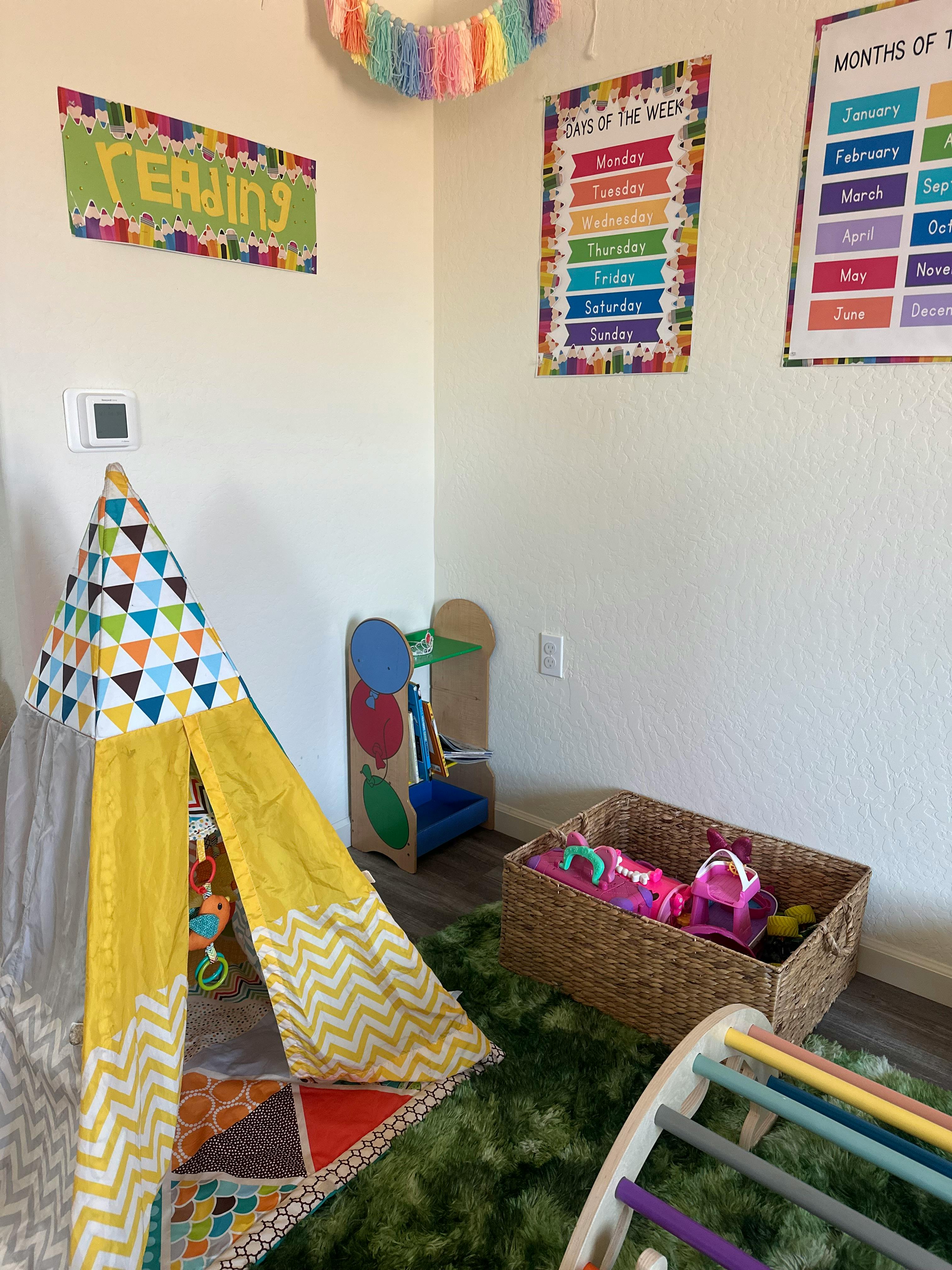 Play area with a children tent, toy basket, and educational wall posters