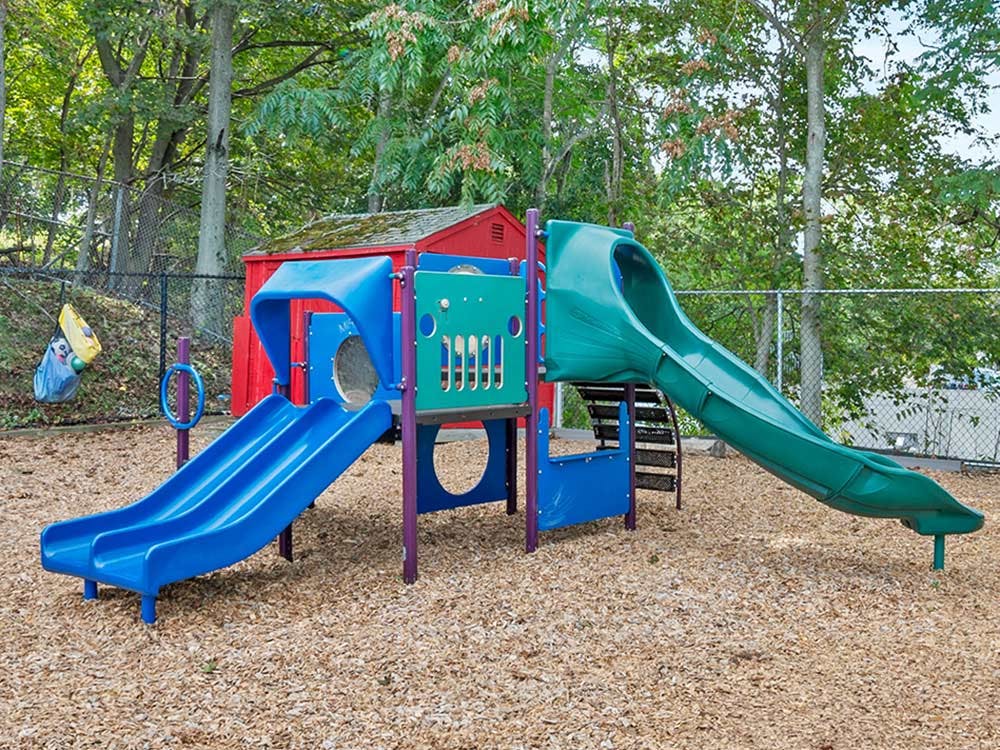 Colorful playground with two slides and a red shed