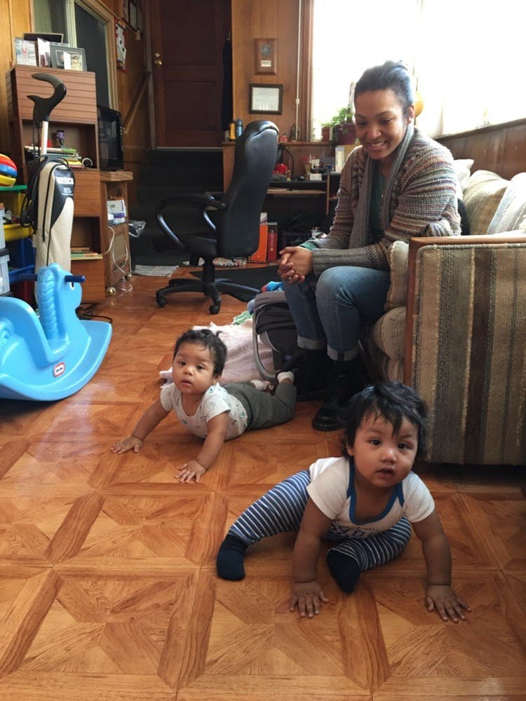Person sitting on a couch watching two crawling children