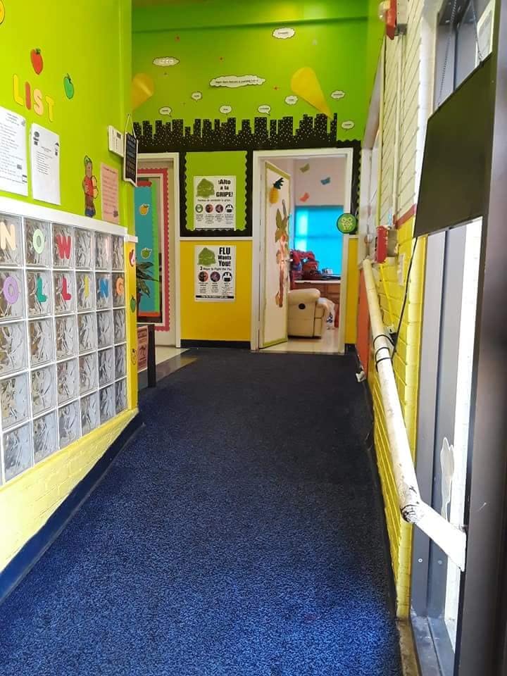 Hallway with blue carpet and colorful walls leading to a room