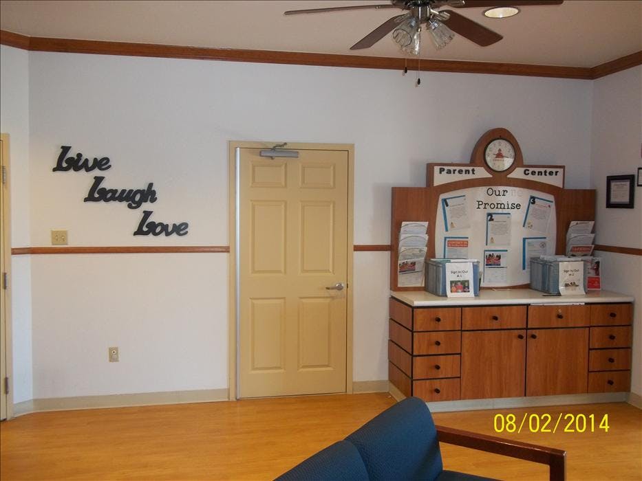 Decorative wall with "Live Laugh Love" text, a door, and a parent information center