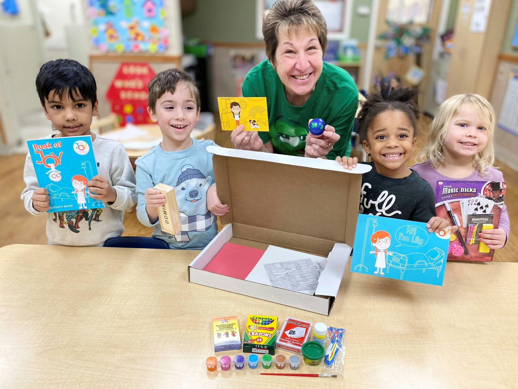 Adult and four children with an open box of craft supplies
