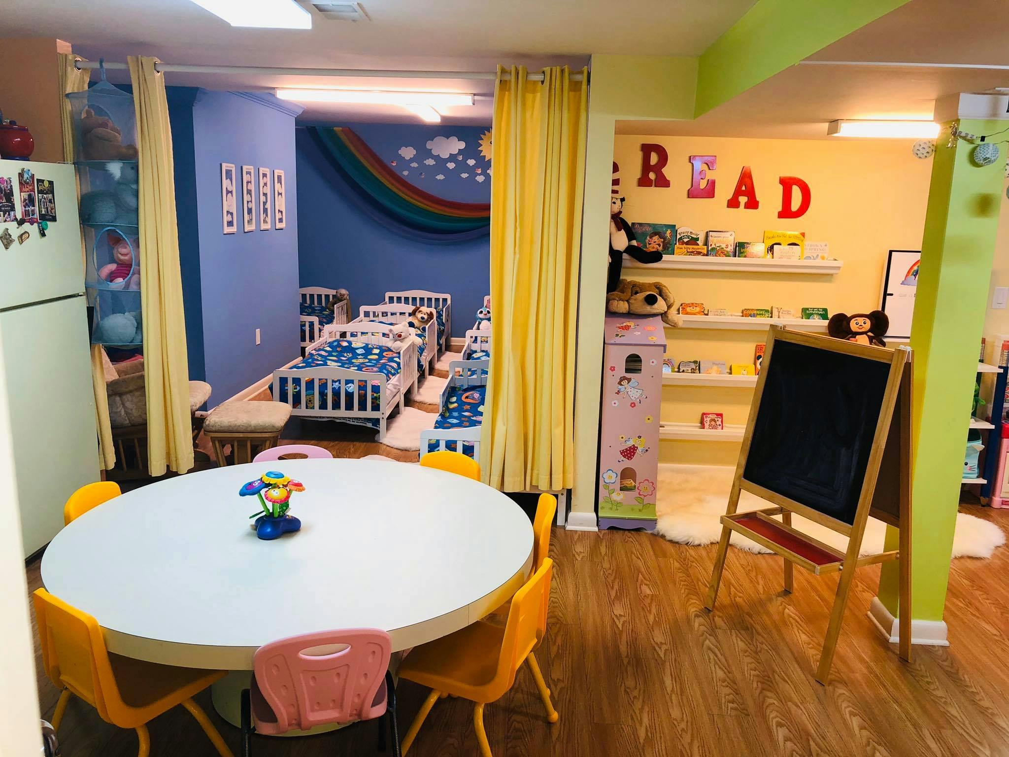 Playroom with a table and chairs, and a separate room with cribs