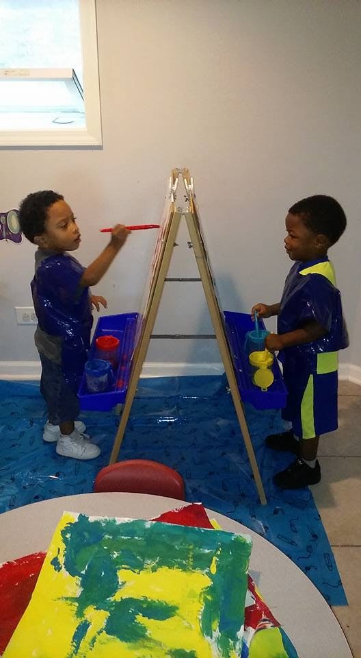 Two children painting at easels