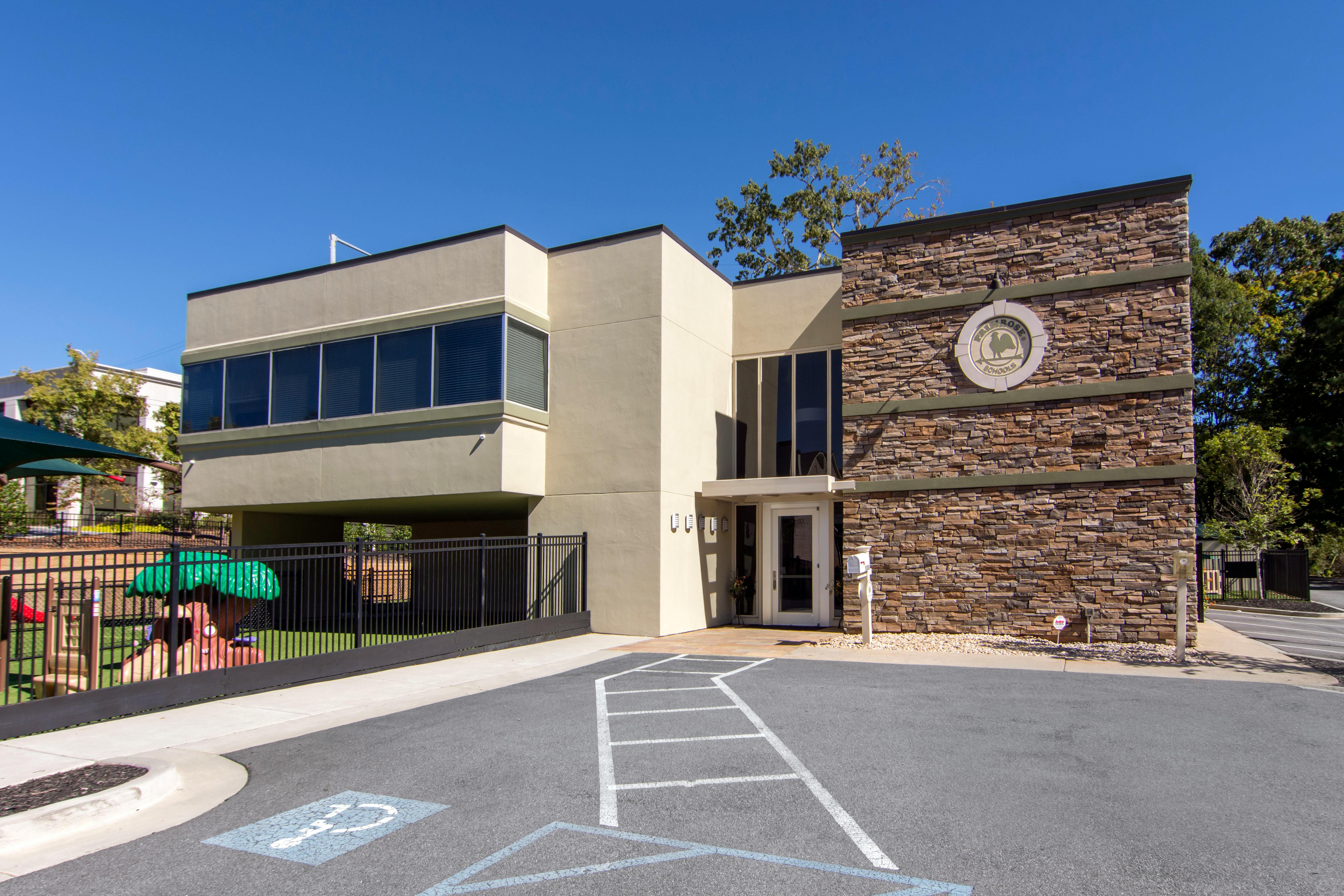 A beige building with stone accents and a circular logo on the right side
