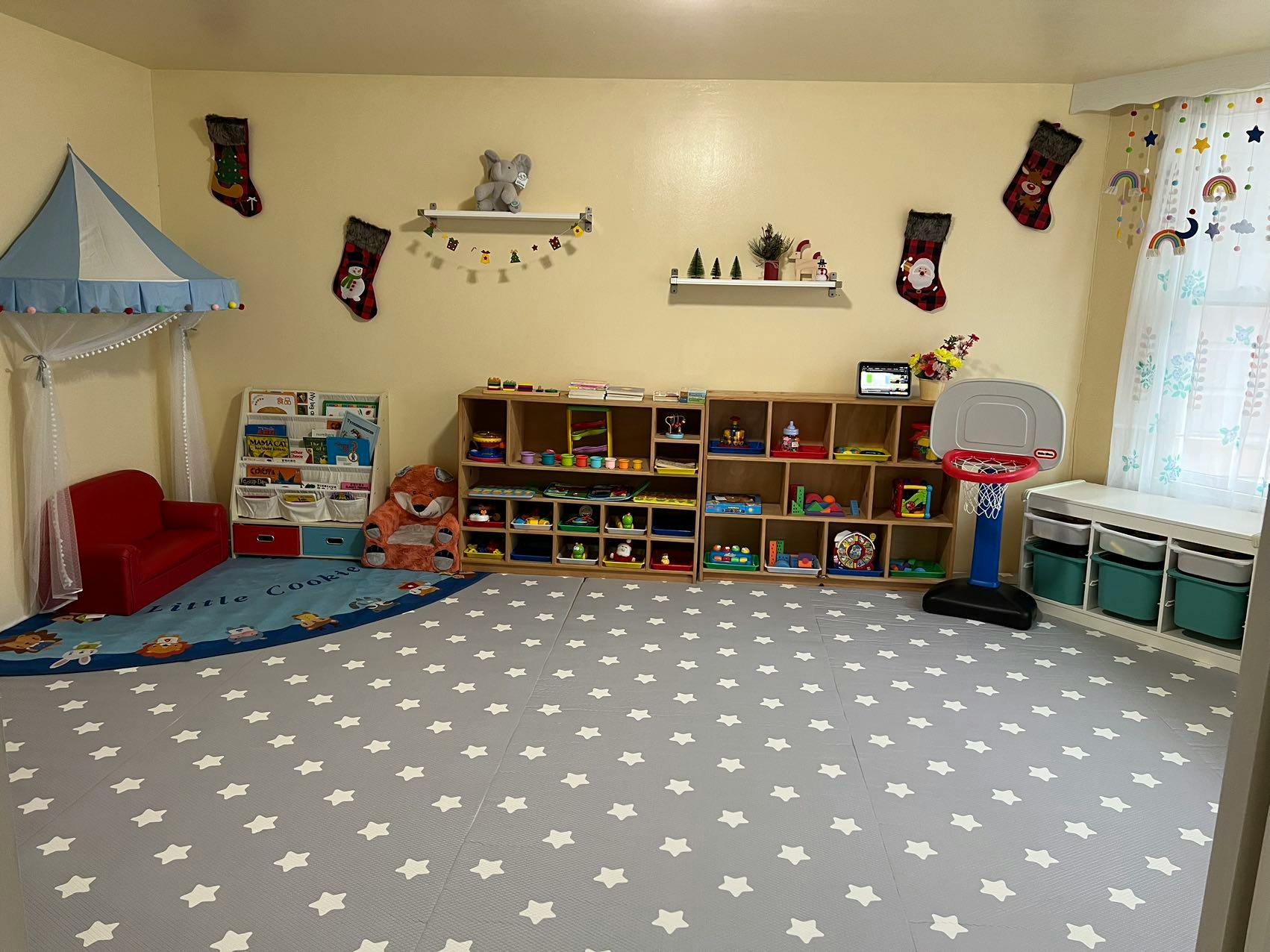 Playroom with shelves of toys, a small red couch, and a basketball hoop